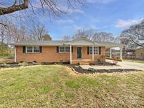 Charming brick ranch home featuring manicured landscaping and a covered carport at 206 Oshea Ave, Gastonia, NC 28056