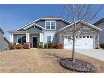 Charming home featuring stone accents, a two-car garage, and inviting front porch with manicured landscaping at 2296 Idol Rock Dr, Indian Land, SC 29707