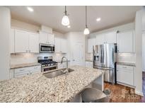 Modern kitchen with white cabinetry, stainless steel appliances, granite countertops, and pendant lighting at 2635 Winter Thistle Way, Indian Land, SC 29707