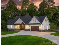 Beautifully constructed home with stone accents, modern architecture, and a driveway with lush green lawn at 3732 Whitney Ne Dr, Hickory, NC 28601