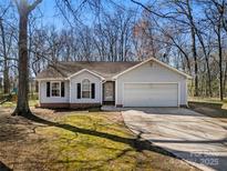 Charming one-story home with light siding, a well-maintained yard, and an attached two-car garage at 4901 Sandstone Ln, Monroe, NC 28110