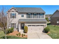 Charming two-story home with a well-manicured lawn and a two-car garage at 7217 Kenyon Dr, Denver, NC 28037