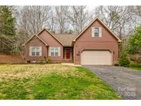 Charming single-Gathering home with brown wood siding, a well-manicured lawn, and an attached two car garage at 8384 Paso Fino Ln, Catawba, NC 28609