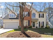 Charming two-story home with brick and siding, a well-manicured lawn, and an attached two-car garage at 8706 Fox Tail Ln, Huntersville, NC 28078