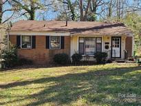 Charming single-story brick home featuring a well-maintained lawn and inviting front porch at 901 Cunningham Dr, Charlotte, NC 28208
