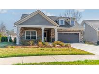 Charming single-Gathering home with a stone and siding facade and a well-manicured lawn at 1005 Headwaters Ct, Matthews, NC 28104