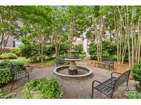 Charming courtyard featuring a fountain, benches, and lush landscaping at 108 Colville Rd # 21B, Charlotte, NC 28207