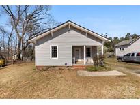 Charming gray bungalow featuring a cozy front porch and well-maintained landscaping at 108 Franklin Ave, Kannapolis, NC 28081