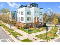 Modern townhome with white siding, brick accents, manicured lawn, and vibrant orange door at 111 W Poindexter Dr, Charlotte, NC 28203