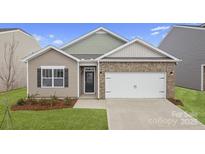 Charming single-Gathering home with brick accents, a two-car garage, and a well-manicured front lawn at 1344 Secrest Commons Ct, Monroe, NC 28112