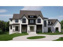 Stunning two-story home featuring a modern design, black window frames, and landscaped front yard at 13820 E Rocky River Rd, Davidson, NC 28036