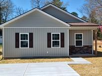 Charming single-story home with gray siding, brown shutters, and a well-manicured lawn at 140 Swimmers Ln, Salisbury, NC 28146