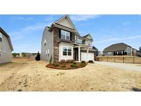 Two-story home featuring a mix of gray siding and brick accents, complemented by a well-manicured lawn at 151 Slip Shot Ln, Troutman, NC 28166