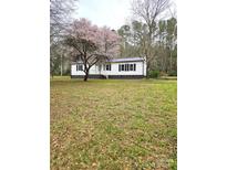 Charming home with a well-maintained lawn and beautiful, mature trees creating a welcoming entrance at 1607 W Nc 27 Hwy, Lincolnton, NC 28092