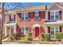 Charming brick townhouse with a red front door and manicured landscaping at 19009 Coachmans Trce, Cornelius, NC 28031