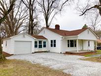 Charming single-story home with white siding and a detached garage in a well-maintained yard at 211 W 1St St, Landis, NC 28088