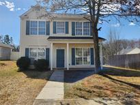 Inviting two-story home with blue shutters and a well-maintained front yard and a sunny day at 2706 Blackberry Ridge Ln, Charlotte, NC 28208
