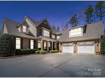 Beautiful brick and stone home featuring a spacious driveway, front porch and a three car garage at 3024 Beaver Dam Dr, Monroe, NC 28110