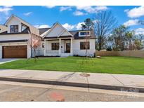 Charming two-story home with a well-manicured lawn, a covered front porch, and a tandem two car garage at 3324 Flamingo Ave, Charlotte, NC 28205