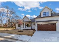 Charming two-story home with a light facade, well-manicured lawn, and a spacious driveway leading to an attached garage at 3328 Flamingo Ave, Charlotte, NC 28205