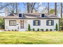 Charming white brick home with black shutters, well-manicured lawn and a modern glass door at 5009 Milford Rd, Charlotte, NC 28210