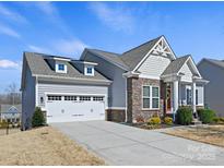 Charming home with a two-car garage, stone accents, and well-manicured landscaping, showcasing curb appeal at 5059 Saint Clair St, Fort Mill, SC 29715