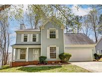 Charming two-story home featuring light blue siding, white shutters, a brick foundation and a well-manicured lawn at 7815 Ambleside Dr, Charlotte, NC 28216