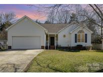 Charming single-story home featuring a well-maintained lawn, attached garage, and inviting front porch at 959 Avery Ct, Concord, NC 28025
