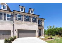 New construction townhome with a two-car garage and stone and brick facade at 104 Kentmore Dr, Waxhaw, NC 28173