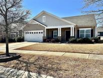 Charming single-story home with attached garage, stone accents, and well-maintained lawn at 11124 Chapeclane Rd, Charlotte, NC 28278