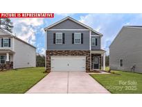 New construction two-story home featuring a two-car garage and stone accents, set in a manicured lawn at 11220 Cardinal Creek Ave, Charlotte, NC 28215