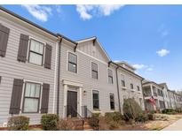 Charming townhome showcasing neat landscaping, light gray siding, and dark brown shutters with a welcoming entrance at 118 Mint Ave # B, Mooresville, NC 28117