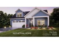 Charming two-story home featuring a spacious garage, inviting front porch, and professionally landscaped yard with exterior lighting at 135 Lake Cove Way # 64, Mooresville, NC 28115