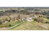 Expansive aerial view of a property featuring multiple homes, a pool, and vast greenery, embodying a serene, estate-like setting at 1620 London Rd, Mooresville, NC 28115