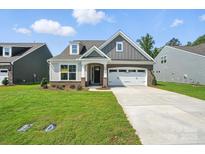 Charming two-story home with a manicured lawn, gray siding and a two-car garage at 4009 Grace Pointe Dr # 101, Indian Trail, NC 28079