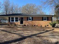 Charming brick ranch-style home with a well-maintained front yard and classic black shutters at 418 Dallas Stanley Hwy, Dallas, NC 28034