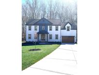 Beautiful two-story home boasts a manicured lawn and a driveway leading to an attached two-car garage at 10405 Briarhurst Pl # 18, Mint Hill, NC 28227