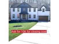 Stunning two-story home featuring a manicured lawn, a modern facade, and a long driveway leading to an attached garage at 10405 Briarhurst Pl # 18, Mint Hill, NC 28227