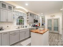 Modern kitchen with grey cabinetry, white countertops, stainless steel appliances, and a butcher block island at 1783 Reepsville Rd, Lincolnton, NC 28092