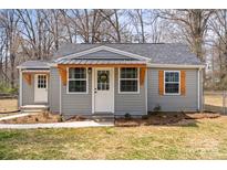 Charming home featuring gray siding, a modern roof, and a beautifully landscaped front yard at 208 Hollifield St, Gastonia, NC 28056