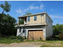 Two-story home featuring a covered upper deck and a gray exterior and a two-car garage at 2725 Celia Ave, Charlotte, NC 28216