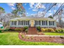 Charming home featuring a symmetrical facade, manicured lawn, and brick accents leading to a bright yellow front door at 3842 Saxonbury Way, Charlotte, NC 28269
