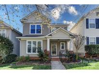 Charming two-story home with a manicured lawn and inviting front porch featuring red roses at 9724 Cadman Ct, Cornelius, NC 28031
