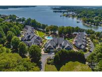 Stunning aerial view of lakefront property, lush trees, and communal pool; beautiful lake views at 101 N Cove Key Ln, Mooresville, NC 28117