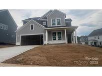 Charming two-story home featuring a spacious garage, inviting front porch, and classic architectural details at 162 Holsworthy Dr, Mooresville, NC 28115