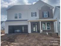 New two-story home featuring a brick facade, covered porch, and an attached two-car garage at 166 Holsworthy Dr, Mooresville, NC 28115
