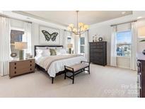 Bright main bedroom featuring neutral walls, carpet, and a decorative chandelier at 166 Holsworthy Dr, Mooresville, NC 28115