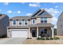 Charming two-story home with a welcoming front porch and a well-maintained lawn at 1875 Loggerhead Dr, Lancaster, SC 29720
