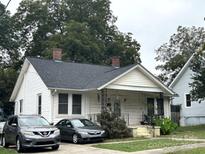 Charming one-story home with black roof, brick chimney, and quaint front porch at 213 S King St, Gastonia, NC 28052