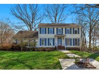 Inviting two-story home with blue shutters and a well-manicured lawn at 2301 Lynbridge Dr, Charlotte, NC 28270